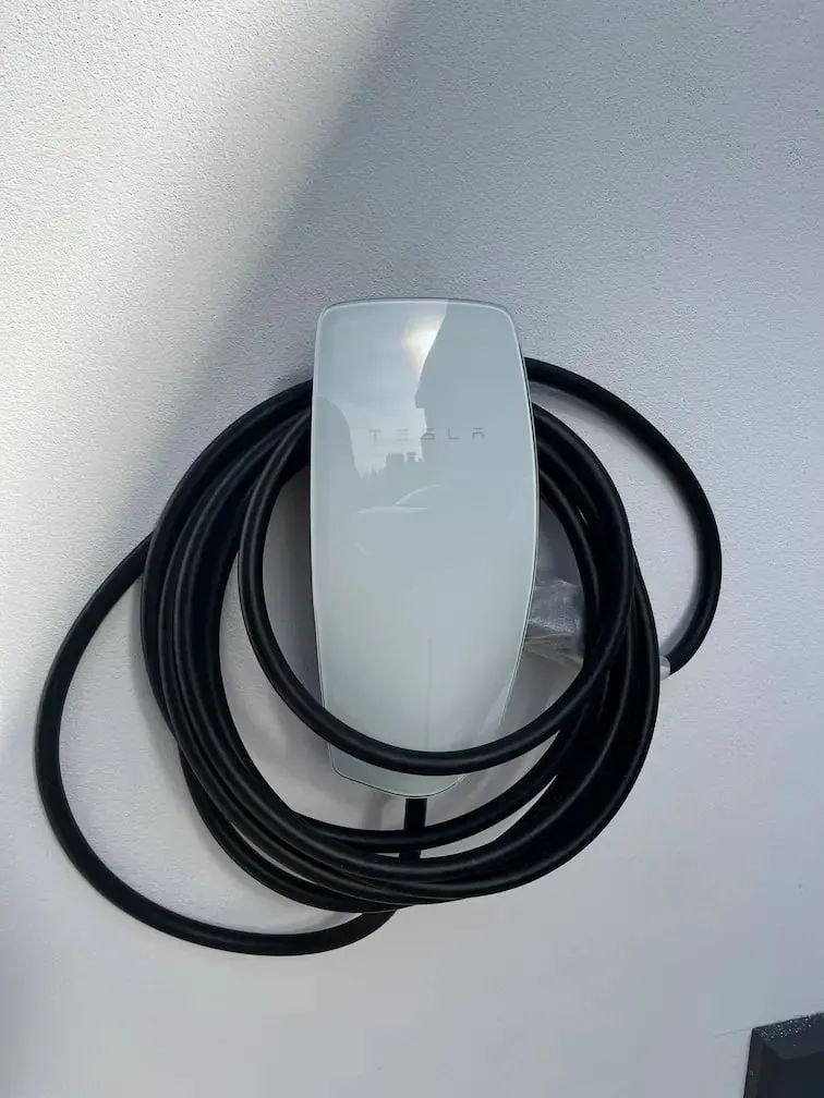 Tesla charger mounted on a garage wall