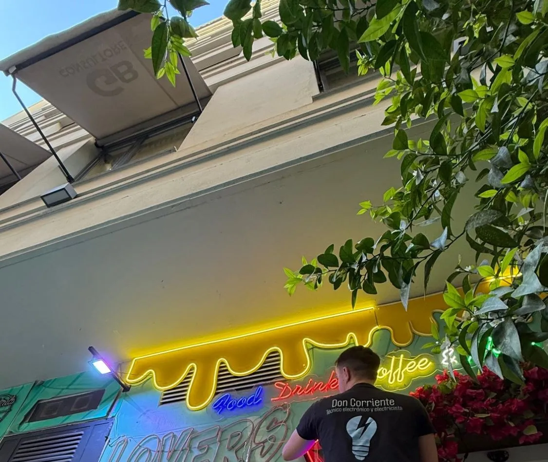 Don Corriente electrician installing a café's LED neon sign